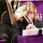 A woman playing the French Horn