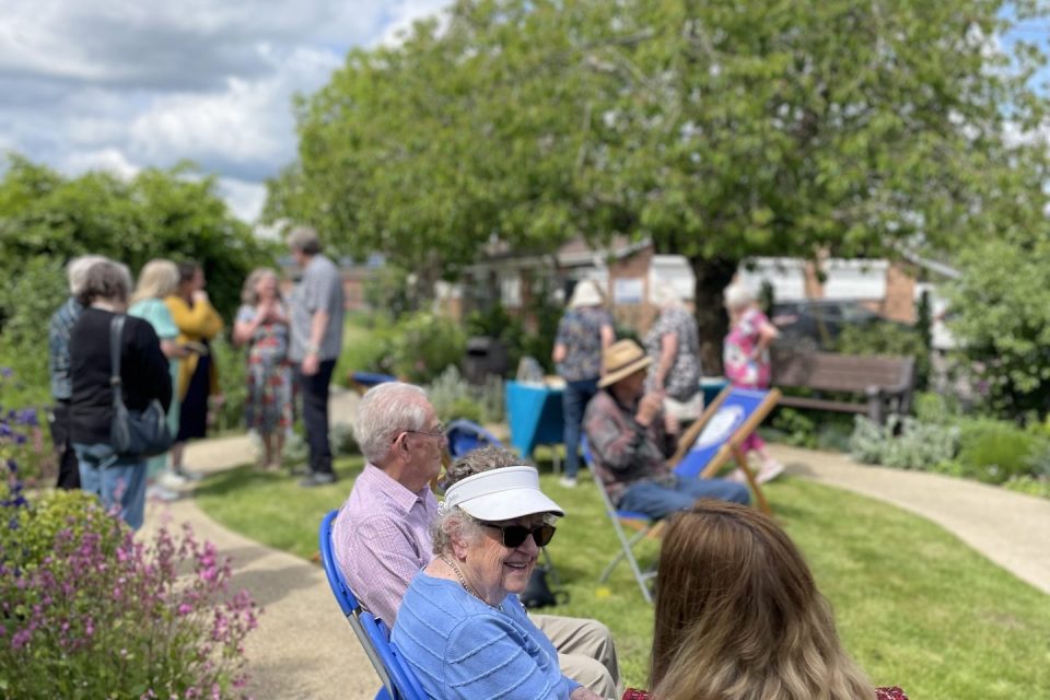 A group of people in casual conversation in a beautiful garden