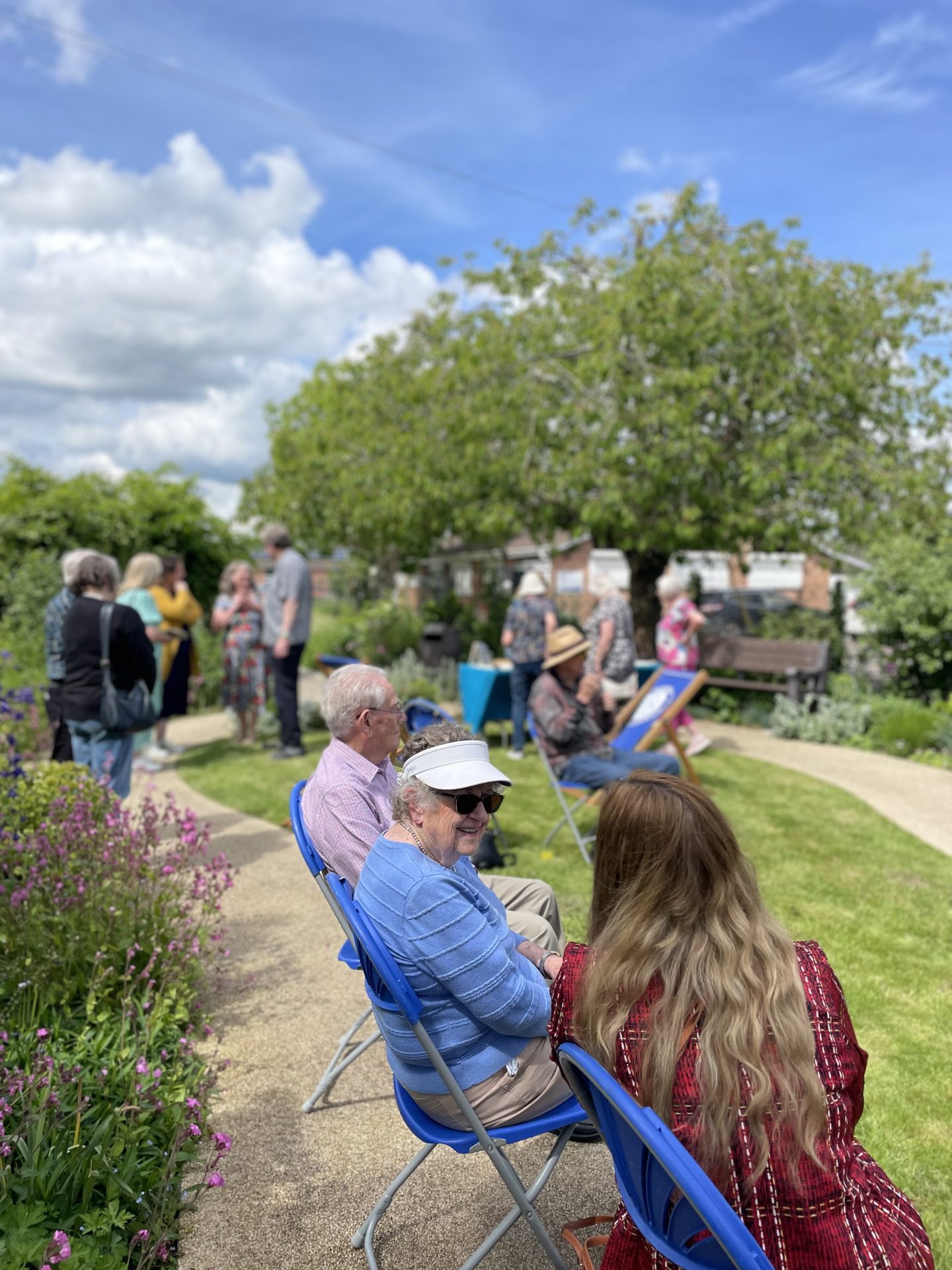 A group of people in casual conversation in a beautiful garden